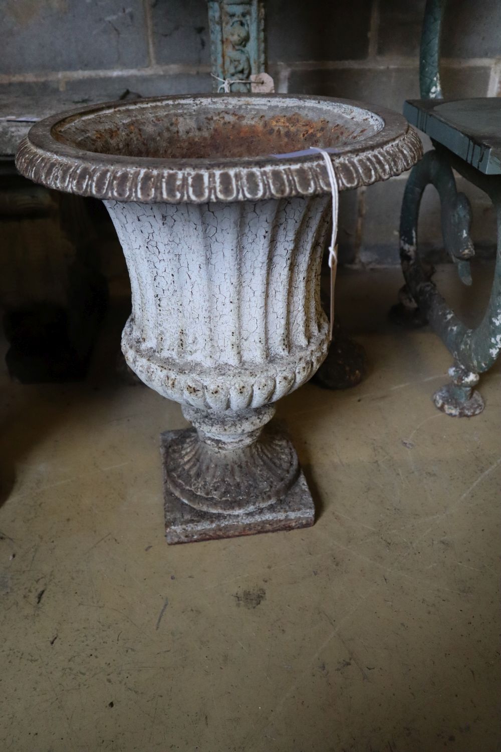 A pair of Victorian cast iron campana garden urns (one lacking plinth foot and rim), taller 49cm